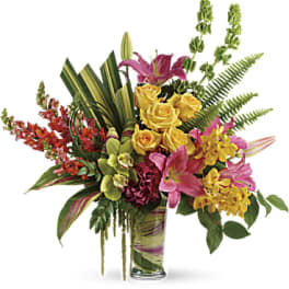 Tropical bouquet with pink lilies, yellow roses, and orchids in a glass vase