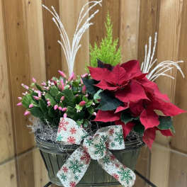 Poinsettia and pink bud arrangement in a green basket with a snowflake ribbon
