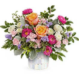 Mixed bouquet of pink, orange, and white flowers in a patterned vase