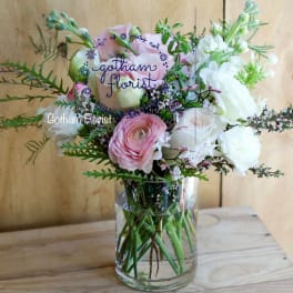 Pink and white flowers arranged in a clear glass vase