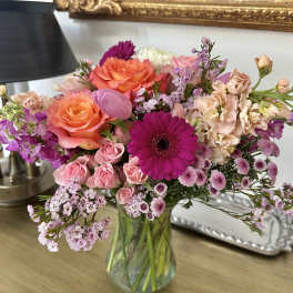 Mixed pink and orange flowers in a glass vase