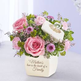 Pink roses and purple flowers in a white vase with a Mother's Day message