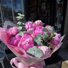 Pink peony bouquet wrapped in pink paper with a ribbon