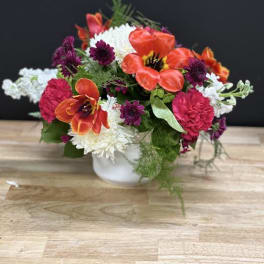 Colorful mixed flower arrangement in a white vase