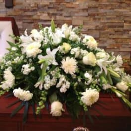 White funeral casket spray with lilies and chrysanthemums