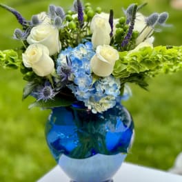 Blue and white floral arrangement in a cobalt glass vase
