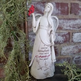 Angel figurine holding a red bird beside trailing greenery