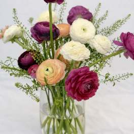Mixed ranunculus bouquet in a clear glass vase
