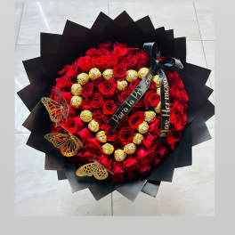 Heart-shaped bouquet of red roses with gold chocolates and black ribbon