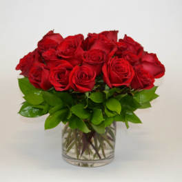Red roses arranged in a clear glass vase