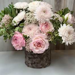 Pink and white roses with white chrysanthemums in a rustic vase