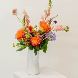 Colorful mixed flower arrangement in a white vase