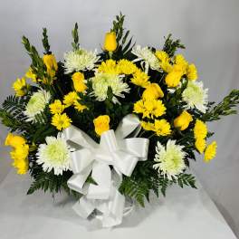 Yellow roses and white chrysanthemums arranged with a white ribbon bow