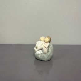 Small figurine of two seated figures in a rounded chair