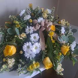 Yellow roses and white daisies arranged with a ribbon bow