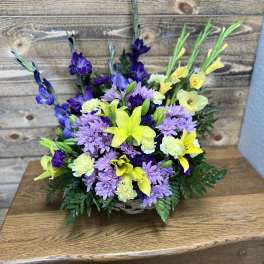 Basket arrangement of purple daisies and yellow lilies