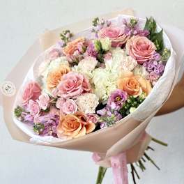 Hand-tied bouquet of pink, peach, and white roses with pastel filler flowers