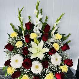 Large red rose and white lily arrangement with yellow carnations and white daisies