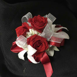 Small cluster of red roses with white ribbon accents