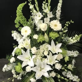 Large white floral arrangement with lilies, roses, and gerbera daisies