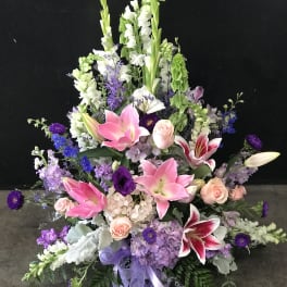 Large floral spray with pink lilies, roses, and purple flowers