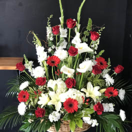 Large basket arrangement with red roses, white lilies, and red gerbera daisies