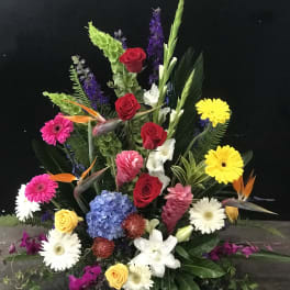 Colorful floral arrangement with roses, gerbera daisies, and birds of paradise