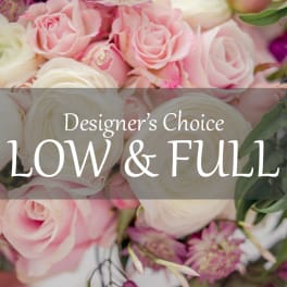Pink and white roses with ranunculus in a low, full arrangement