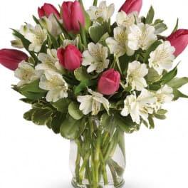 Pink tulips and white alstroemeria in a clear glass vase