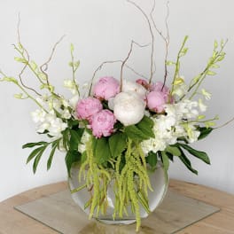 Pink and white peonies in a clear glass bowl vase