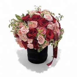 Bouquet of red and pink roses in a black hatbox