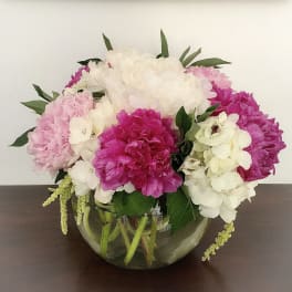Pink and white hydrangea bouquet in a round glass vase