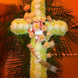 Cross-shaped floral tribute with white chrysanthemums and peach roses