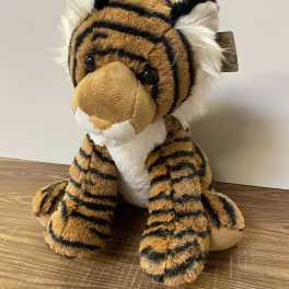 Plush tiger stuffed animal sitting on a wooden surface