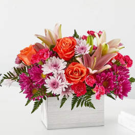 Mixed bouquet of roses, lilies, and daisies in a white box