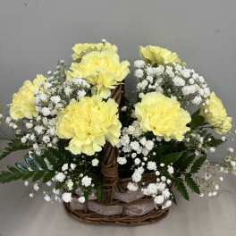Yellow carnations and white baby's breath in a wicker basket