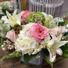 Pink and white floral arrangement in a gray vase