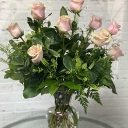 Pink roses arranged in a clear glass vase