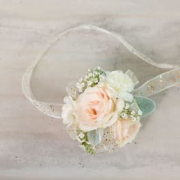 Small peach and white floral wrist corsage with sheer ribbon