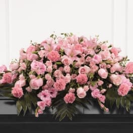 Pink floral casket spray with roses and lilies