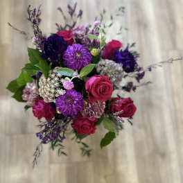 Bouquet of pink roses and purple flowers with greenery