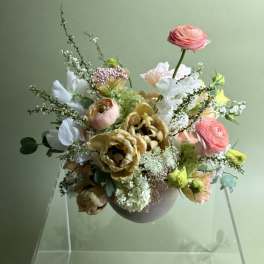 Mixed bouquet in a round vase with pink, white, and yellow blooms