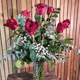 Bouquet of red roses with baby's breath in a clear glass vase
