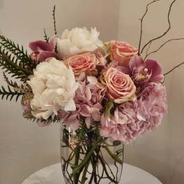 Pink and white floral arrangement in a clear glass vase