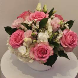Pink roses and white hydrangeas arranged in a white bowl vase