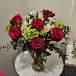 Red roses and white alstroemeria in a clear glass vase