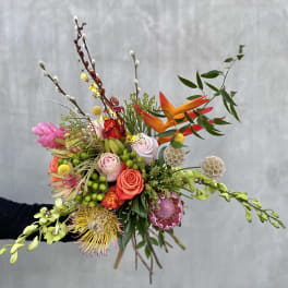 Colorful hand-tied bouquet with roses, orchids, and tropical blooms