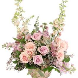 Basket arrangement of pink roses and lavender flowers