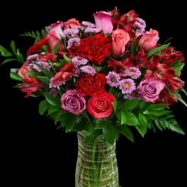 Bouquet of pink and red roses with carnations in a glass vase