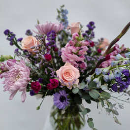 Mixed bouquet of pink and purple flowers in a glass vase